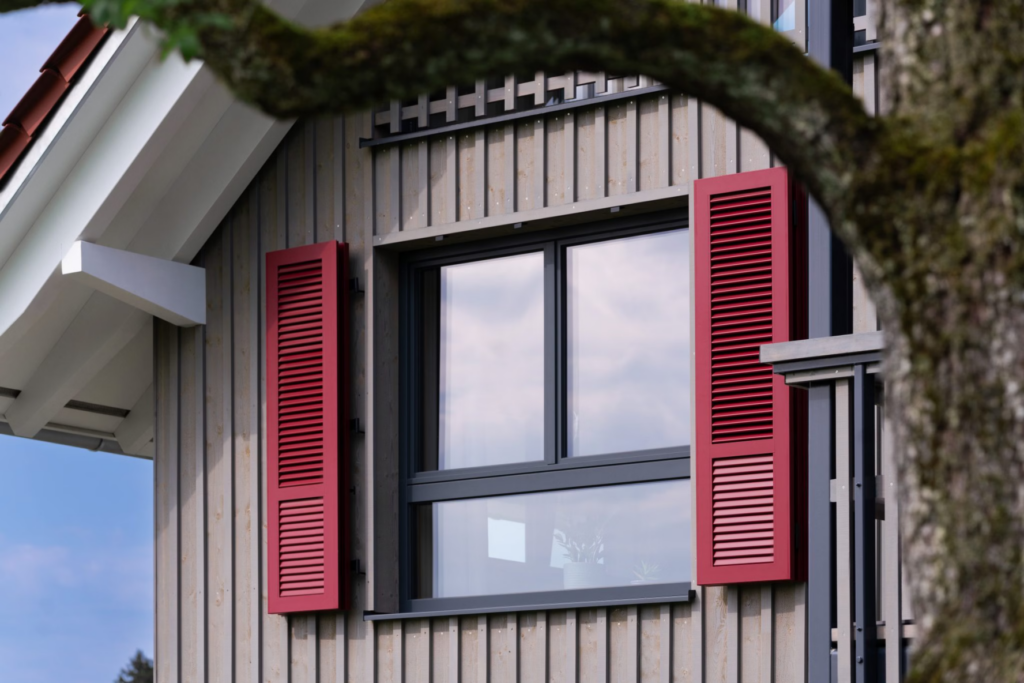 Volets battants aluminium gris à lames horizontales sur une maison contemporaine