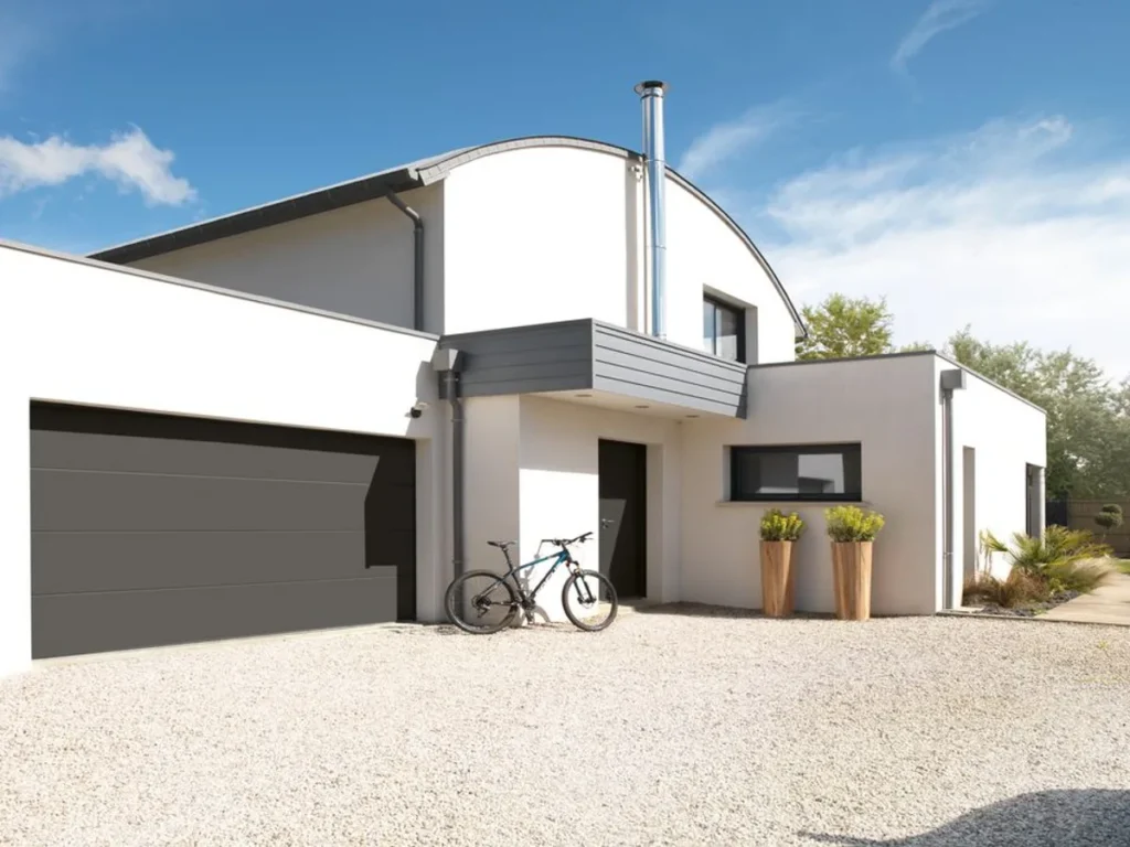 Porte de garage sectionnelle gris anthracite à panneaux lisses sur une maison contemporaine