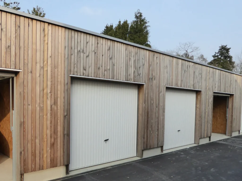 Porte de garage basculante à nervures verticales sur un box de maison individuelle