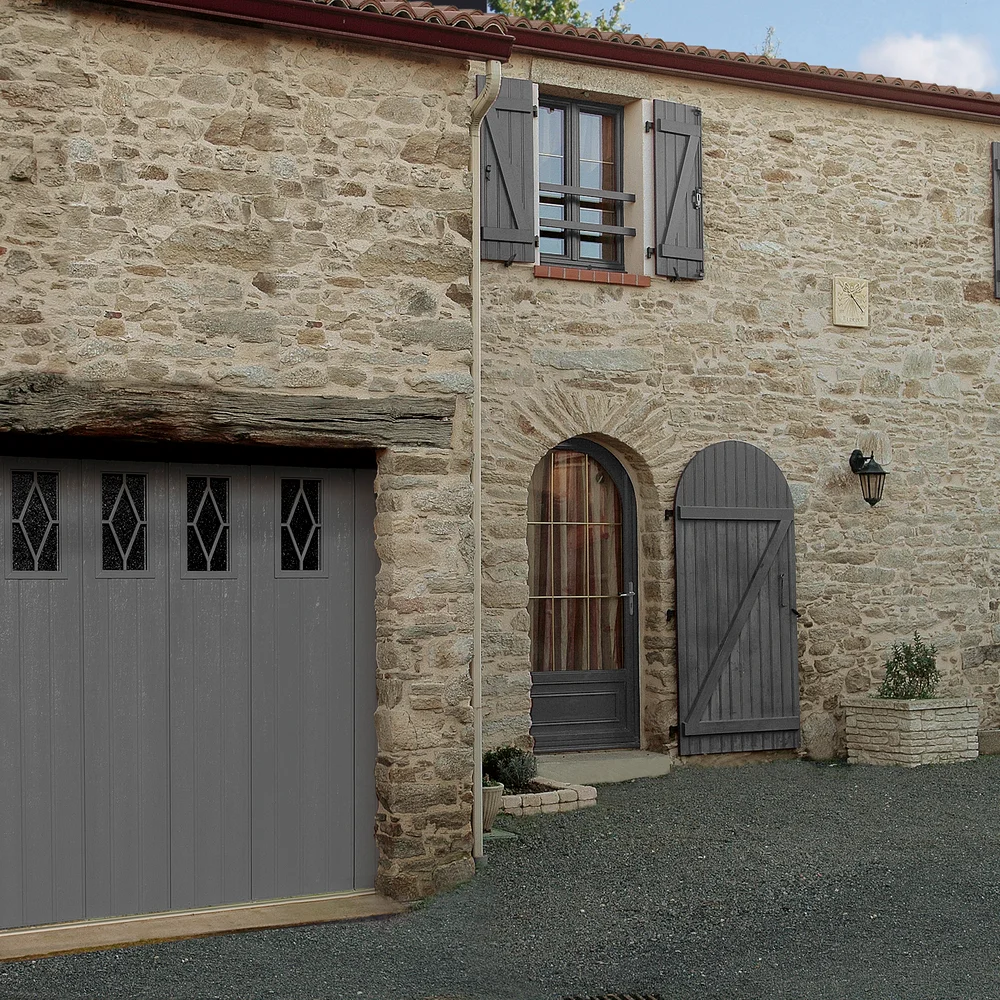 Porte de garage latérale grise à nervures et hublots ronds, style traditionnel