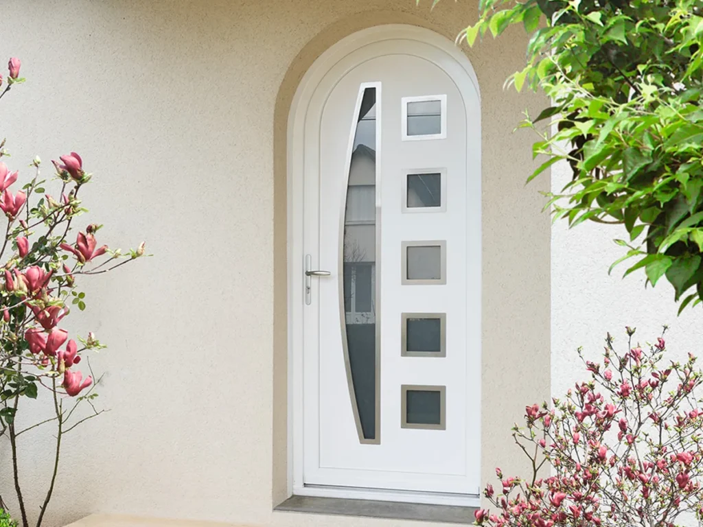 Porte d’entrée PVC blanche cintrée avec vitrage décoratif, sur une façade beige